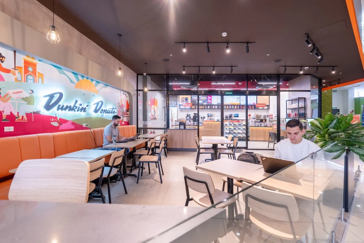 Dunkin Donuts - Cafe seating area with orange branding elements and modern furniture - Contract Workplaces.webp